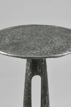 a round metal table sitting on top of a white floor