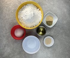 four bowls with different types of food in them on a counter top next to measuring cups and spoons