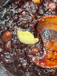 a wooden spoon in a pot filled with beans and other things to make it look like they are cooking