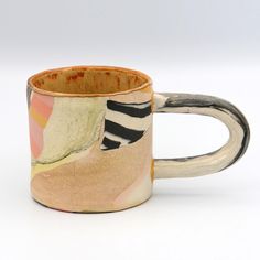 a coffee mug with an abstract design on the outside and inside, sitting on a white surface