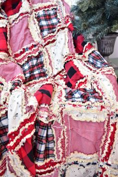 a red and black plaid blanket sitting next to a christmas tree