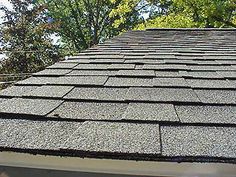 the roof of a house that has been gutted with shingles and some trees in the background