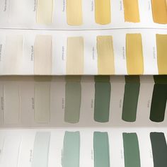 several shades of green and yellow paint on display in a room with the same color swatches