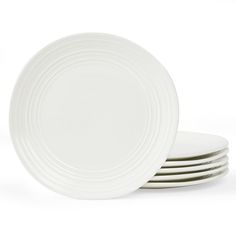 four white plates stacked on top of each other in front of a white background,