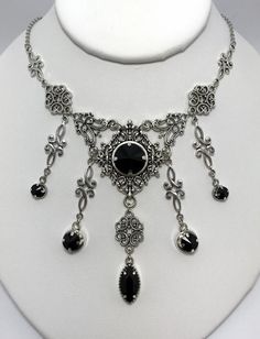 This is a new handmade necklace. It is made with antiqued silver plated filigrees, accented with high quality JET BLACK glass jewels/rhinestones that sparkle like crystals. Decorated portion is 6 1/2" wide and 3 1/4" tall in the center. Necklace is adjustable 15-18" with a lobster clasp and chain extender. If you would like a different length, please send us a message.Matching earrings and headpiece are listed in our store. Gothic Metal Jewelry For Fantasy Events, Black Gothic Jewelry For Fantasy Events, Gothic Silver Necklaces For Festival, Silver Gothic Necklaces For Fantasy Events, Gothic Metal Necklace, Silver Gothic Jewelry For Fantasy Events, Silver Necklace For Fantasy Events, Handmade Gothic Jewelry For Fantasy Events, Black Gothic Necklace For Fantasy Events