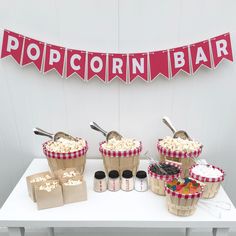 popcorn bar set up on a table with red and white banner