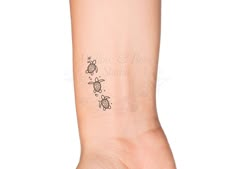 a woman's arm with a small turtle tattoo on it