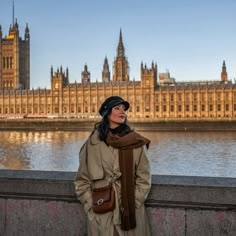 a woman standing in front of big ben and the houses of parliament, london england