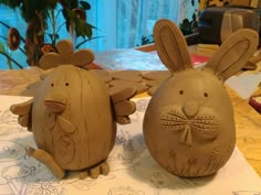 two clay rabbits sitting on top of a table