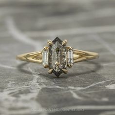 a yellow gold engagement ring with an oval cut diamond surrounded by three baguets