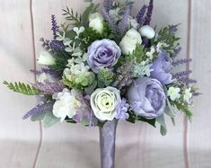 a purple and white bouquet sitting on top of a chair