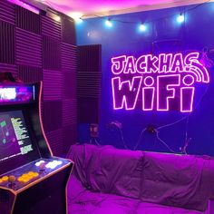 a purple room with neon lights and an arcade gaming machine in the corner that says, jackhauss wifi