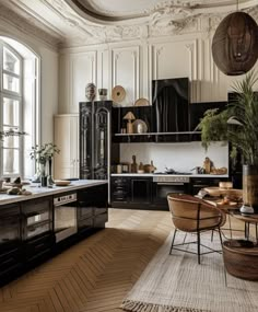 the kitchen is decorated in black and white with lots of natural light coming from the windows