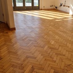 an empty room with wooden floors and doors