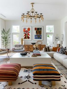 a living room filled with furniture and a chandelier hanging over the top of it