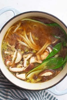 a pot filled with soup and vegetables on top of a table