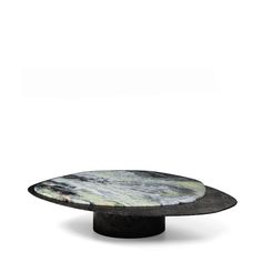 a black and white table with a circular marble plate on the top, in front of a white background