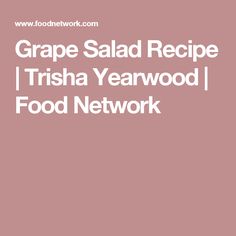 the words grape salad recipe trisha yearwood food network are in white on a pink background