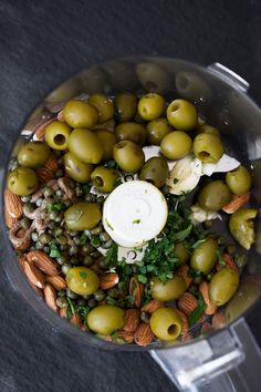 a food processor filled with green olives and nuts