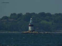 a light house sitting on top of a small island in the middle of the ocean