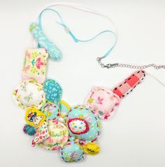 a multi - colored necklace with various items attached to it on a white table top