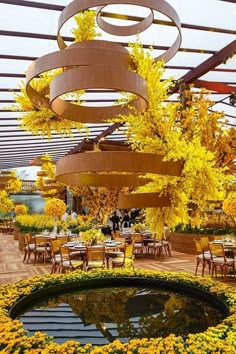 an outdoor dining area with yellow flowers and circular chandelier hanging from the ceiling