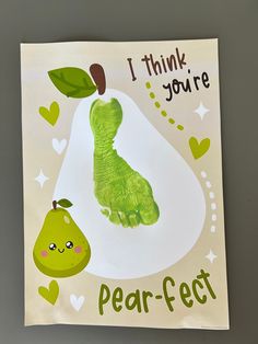 a card with a green handprinted caterpillar next to a pear on it