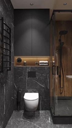 a modern bathroom with black marble walls and flooring, along with a white toilet