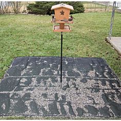 a sign that is sitting on top of a black tarp in the middle of a yard