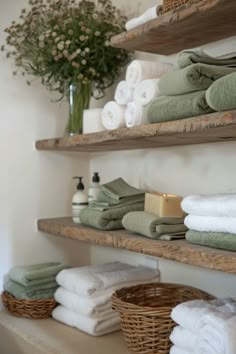 towels are stacked on shelves in a bathroom