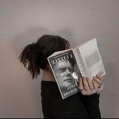 a woman reading a book with her head in her hands