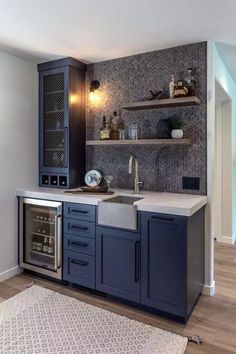 a kitchen with blue cabinets and white counter tops is shown in this image, there are shelves on the wall above the sink