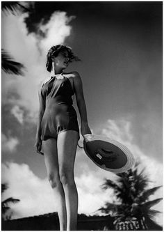 a woman in a bathing suit holding a frisbee