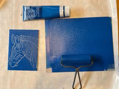 a pair of scissors sitting on top of a piece of paper next to some blue paint