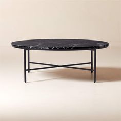 a black marble coffee table sitting on top of a white floor