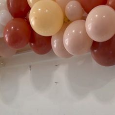 a bunch of balloons that are hanging from the side of a wall in a room