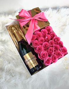 pink roses in a gift box with a bottle of champagne