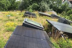 there are many old televisions that have been placed in the grass on top of each other