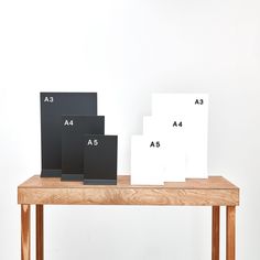 three black and white cards sitting on top of a wooden table next to each other