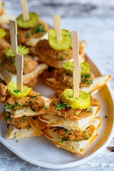 several appetizers are arranged on a plate with toothpicks