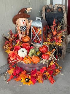 a basket filled with pumpkins and gourds sitting on the ground next to a lantern