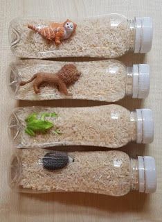 three plastic bottles filled with different types of food and animals on top of rice krispy kreme