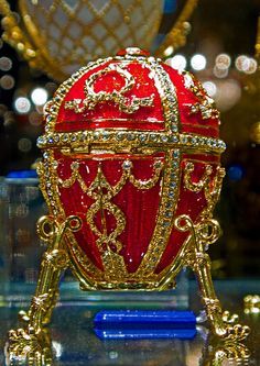 an ornate red and gold egg on display