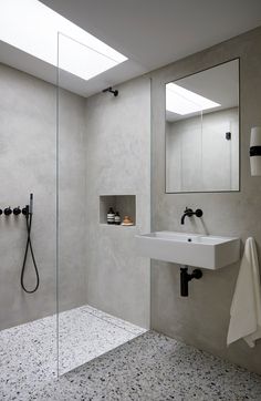 a bathroom with a sink, mirror and shower head in the corner next to it