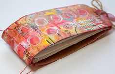 an open book is sitting on a table with some string attached to the front cover