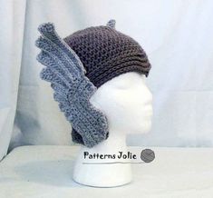 a crocheted hat with wings on top of a mannequin head