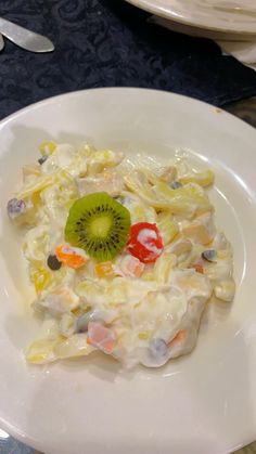 a white plate topped with fruit and veggies on top of a blue table