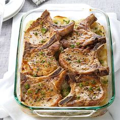 a casserole dish filled with meat and vegetables on top of a white table cloth