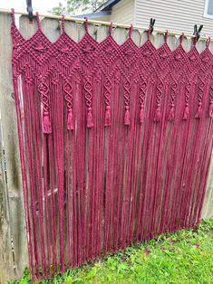 a fence with red yarn hanging from it's sides