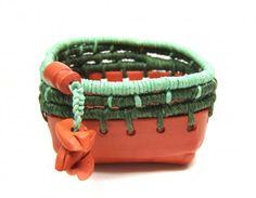 a close up of a small boat with green and orange beads on it's sides